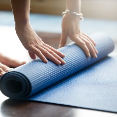 Una persona extiende su colchoneta de yoga para ejercitarse
