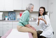 Photograph of a female doctor discussing medication with a female patient